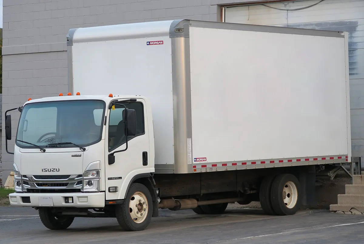White 2024 Isuzu NPR-HD box truck, front left view